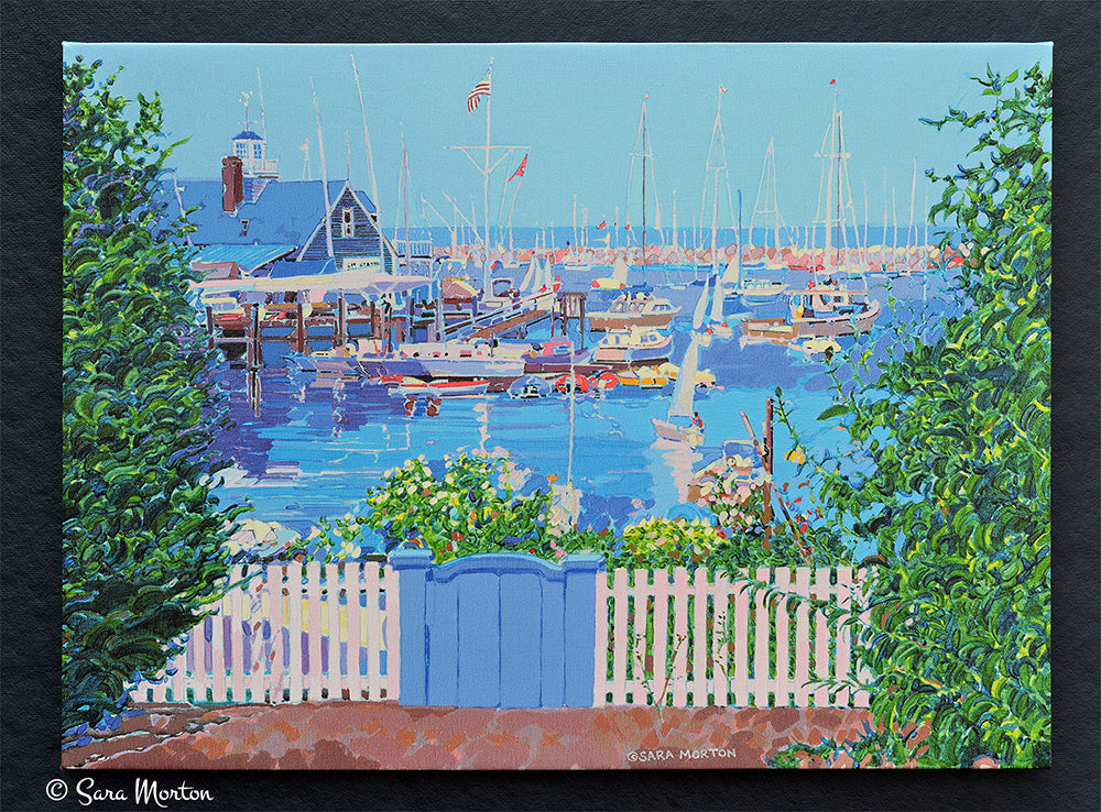 Front view of Rockport MA Harbor “Harbor Inlet” painting printed on canvas, featuring boats, Sandy Bay Yacht Club, and white picket fence with blue gate.