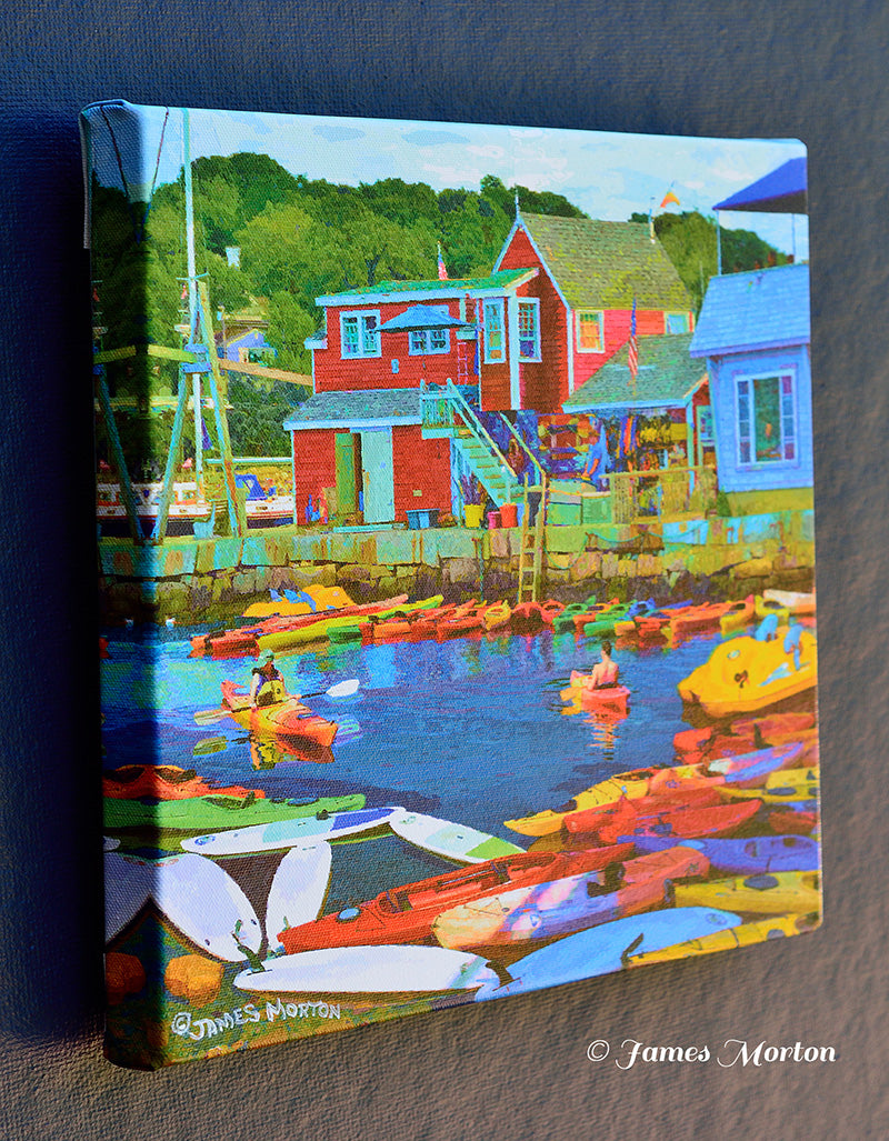 Left side view of 12x12 inch canvas print of 'Rockport Kayaking' by James Morton, highlighting the striking red North Shore Kayak building against the stony sea wall.