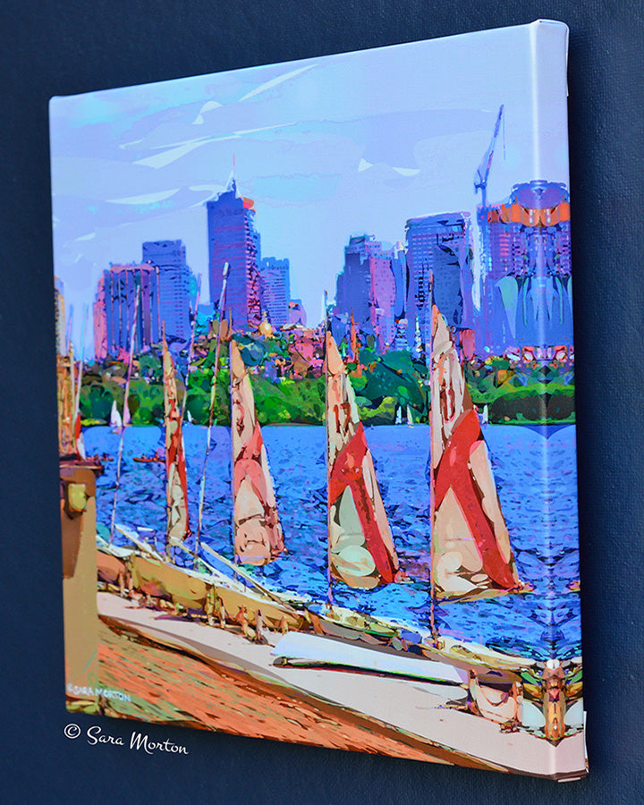 MIT sailboats docked on Charles River in Cambridge, MA with a Boston city skyline in the background.