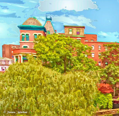 Close-up detail of Baker's Chocolate Square art print featuring the chocolate factory building against a blue sky, surrounded by lush green trees in Milton MA