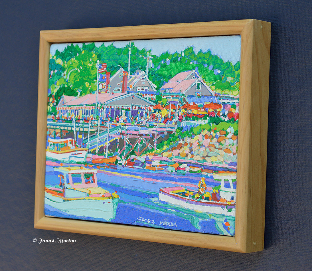 Right side angle view of a framed original Perkins Cove painting in Ogunquit, Maine featuring Barnacle Billy's restaurant, working harbor, fishing boats, and coastal landscape.