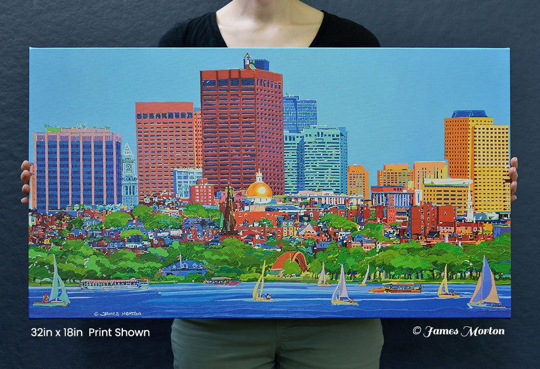 Person holding a 32 × 18 ready-to-ship Boston skyline canvas print featuring Beacon Hill, the Charles River, sailboats, the Hatch Shell, Union Boat Club Boathouse, and the Massachusetts State House for size reference.