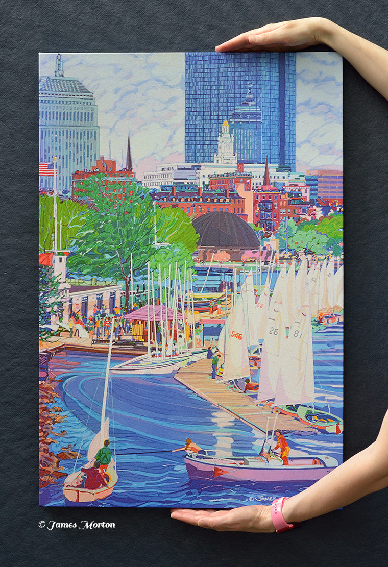 Hand-held view of a ready-to-ship Boston skyline canvas print featuring Community Boating sailboats, the Charles River, John Hancock Tower, the Berkeley Building, and the New England Mutual Life Insurance Building.
