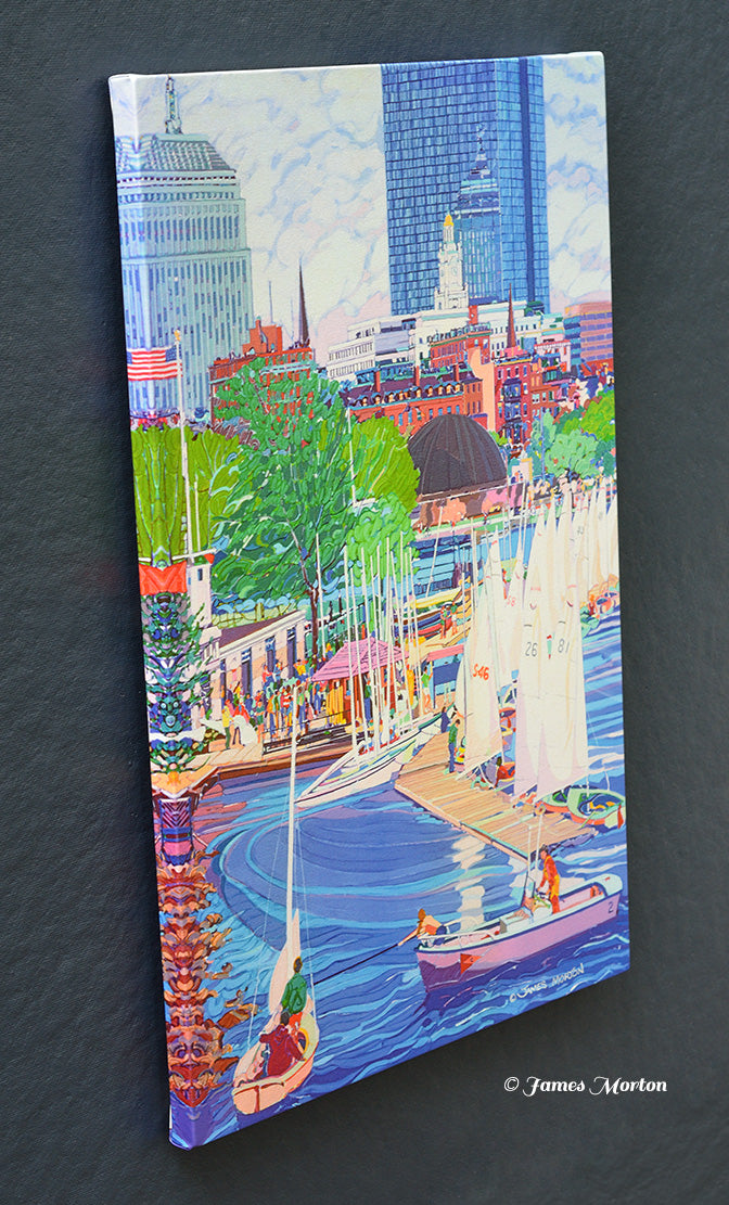 Angled view of a stretched Boston canvas print depicting sailboats gathered at the Community Boating Boathouse along the Charles River Esplanade, with the Back Bay skyline, John Hancock Tower, and Hatch Shell beyond.
