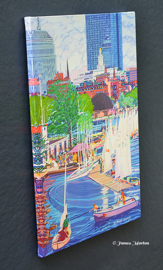Angled view of a stretched Boston canvas print depicting sailboats gathered at the Community Boating Boathouse along the Charles River Esplanade, with the Back Bay skyline, John Hancock Tower, and Hatch Shell beyond.
