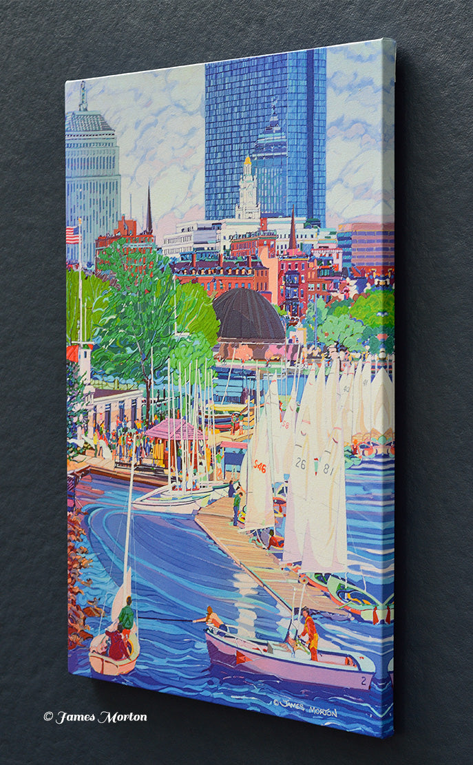 Right-side view of a stretched Boston skyline canvas print showing sailboats at Community Boating Boathouse on the Charles River with the Back Bay skyline in the distance. James Morton signature visible in the lower right.
