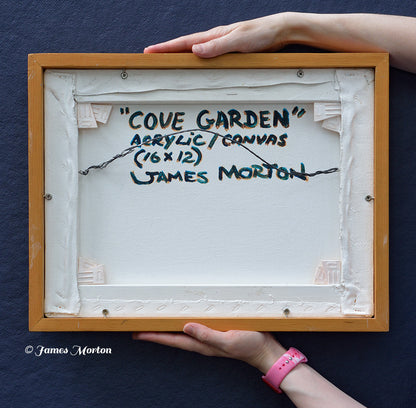 Back of the framed original acrylic painting Cove Garden, hand signed, titled, and labeled by artist James Morton. Original Wellfleet, Massachusetts coastal landscape artwork on canvas in a handcrafted wood frame, wired and ready to hang, shown held for scale