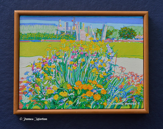 Framed original acrylic painting of a Wellfleet, Massachusetts coastal garden with colorful flowers, green grass, and a wooden dock leading to a tidal marsh with blue water. Artist James Morton's signature is visible in the bottom right corner.