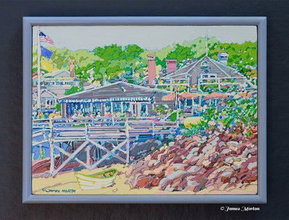 Framed original Ogunquit, Maine acrylic painting on linen depicting Perkins Cove with Barnacle Billy's restaurant, a quiet shoreline, small rowboat, rocky beach, and lush green trees. Hand signed by artist James Morton.