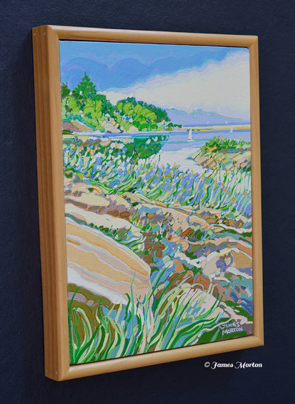 Left angle view of Ocean Pond, an original acrylic painting by James Morton depicting Ogunquit's Marginal Way with rocky Maine coastline, beach grasses, green trees, calm ocean water, and billowing clouds in a light wood frame.