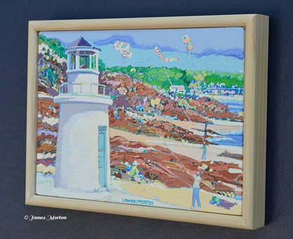 Right-angle view of a framed original Maine coastal painting showing Lobster Point Lighthouse overlooking the rocky shoreline, Atlantic Ocean, and summer beach scene.